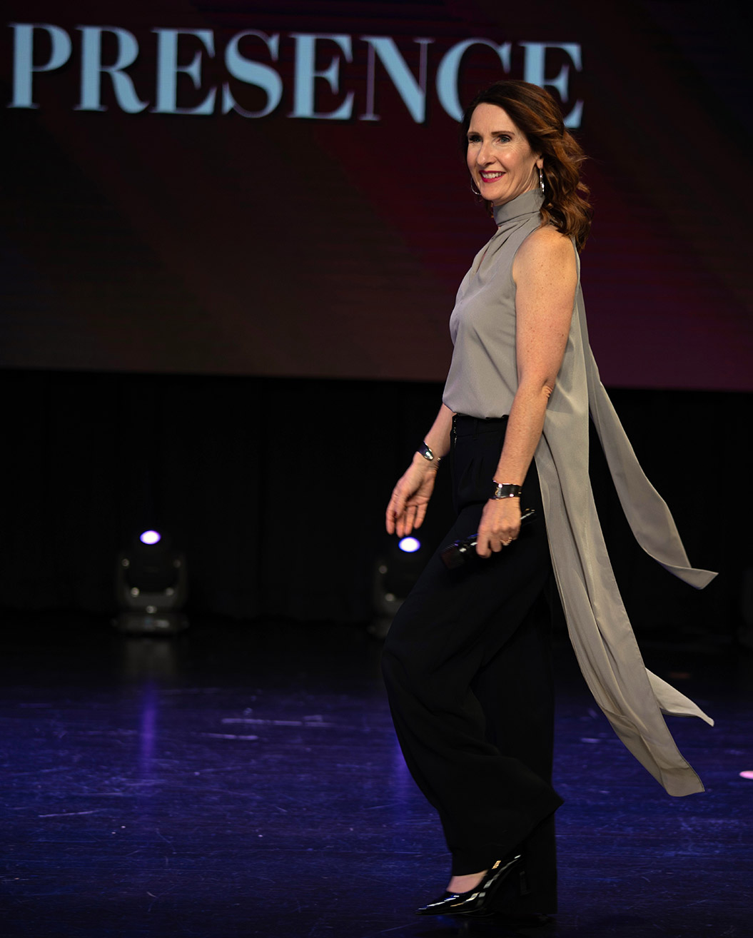 RJ on stage with the word PRESENCE behind her