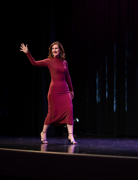 Rachael-Jayne walking across stage in red dress
